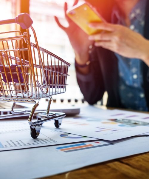 Cropped image of woman inputting card information and key on phone or laptop while shopping online.